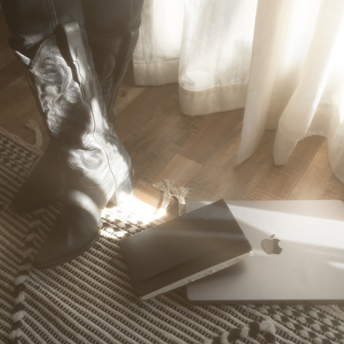 A copywriter stands next to her laptop and journal.